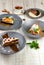 Set of four plates with desserts. Chocolate and carrot cake, apple and cranberry strudel, caramel pumpkin pie. Lunch menu of food