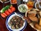 Set of fried mushrooms, tomato, cucumber and beer on a wooden table.