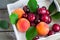 Set of fruit: peaches, plums, cherries on a white tray