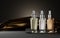 Set glass bottles cosmetics on dark background with gold fabric. Night serum, tonic or perfume. Skincare beauty product