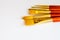 Set of golden bristle paint brushes on white background with copy space