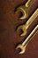 Set of golden wrenches on rusty background