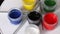 A set of gouache and brushes. Open cans of paint.  Rotate on the subject table. Close-up