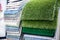Set of green, grass-like wool, white and blue carpets in store