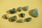 Set of green pebble stones at yellow sunny table