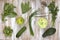 Set of green vegetables on white painted wooden background: kohlrabi, avocado, brussels sprouts, apple, cucumber, green onion, pea