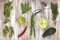 Set of green vegetables on white painted wooden background: kohlrabi, avocado, brussels sprouts, apple, pepper, green onion, pea