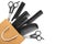 a set of hairdressing combs and scissors in black color in a craft package on a white isolated background