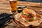 Set of hamburger beer and french fries. A standard set of drinks and food in the pub, beer and snacks. Dark background