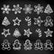 Set of hand-drawn outlined doodle cookies. Gingerbread men, Christmas tree, star, snowflakes. black background. Chalk on