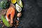 A set of healthy food for keto diet on a dark background. Fresh raw salmon steak with flax seeds, broccoli, avocado, chicken eggs