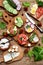 Set of healthy whole wheat bread sandwiches with fuits, vegetables, cheese and leafy green herbs on picnic wooden table. Ciabatta