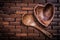 Set of heartshaped wood bowl and spoon on wooden backcloth