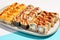 Set of hot maki sushi on ceramic dishware. Baked sushi set in minimal style. Tempura rolls in modern concept. Japanese menu in