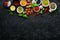 Set of Indian fragrant spices and herbs on a black stone background.