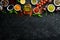 Set of Indian fragrant spices and herbs on a black stone background.