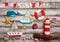 Set of kids handcrafted boats, fish, nautical attributes and more on rough vintage wooden background top view