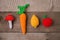 Set of knitted toys lemon, carrot, apple, amanita on wooden background. Earlier tactile development of children, craft toys