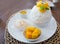 Set of Korean ripe mango Bingsu, sweetened condensed milk dessert, sticky rice, serving on white ceramic plate. Unhealthy dessert
