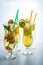 Set lemonade with ice in glass hurricane with tropical fruits