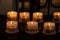 Set of lit church candles in a line with the illustration of the Virgin Mary and baby Jesus