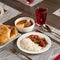 Set lunch from rice with vegetables, soup with meat broth, samsa and red compote on blurred background. Beautifully