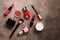 Set of makeup products on a dark rustic background. Flat lying decorative cosmetics. View from above