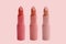 Set of matte lipstick on a delicate pink background, red, raspberry, pink, coral, peach color, close-up, the concept of decorative