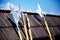 Set of middle age style weapons leaning on wooden tiled roof.