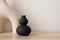 Set of modern ceramic vases of geometric organic shape on wooden table. Modern black sculpture. Beige wall. Abstract