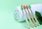 Set of multi-colored wooden toothbrushes, white towel, green leaf on a green background. The concept of zero waste, medicine,