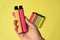 Set of multicolor disposable electronic cigarettes on a bright yellow background.