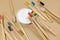 A set of multicolored eco-friendly bamboo toothbrushes and white tooth powder on a beige pastel background. Zero-waste,