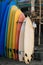 Set of multicolored surf boards in a stack by ocean.Bali.Indonesia. Surf boards on sandy beach for rent. Surf lessons on