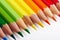 Set of multicoloured pencils lying on white table