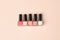 Set of nail polish bottles neutral natural colors on beige background. Concept of pallete for french manicure, woman beauty