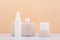 Set of natural organic beauty products for daily skin care with beige podiums against beige background.