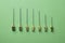 Set of needles for old syringes of different sizes and thicknesses. Green background