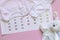 Set of newborn accessories in anticipation of  child - calendar with circled number 11 eleven, baby clothes, toys on pink