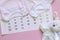 Set of newborn accessories in anticipation of  child - calendar with circled number 29 twenty nine, baby clothes, toys on pink