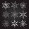 Set of nine vintage vector illustration christmas snowflakes on chalkboard background. flourish calligraphic handmade