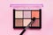 Set of nude eyeshadows in black case on pink background. Top view , copy space