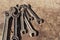 Set of old spanners of various sizes on a rusty painted metal table.