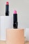 Set of open lipsticks on trendy pedestal, unbranded presentation of cosmetics