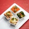 Set of oriental salads. Four kinds of spicy Thai vegetable snacks in white salad bowls. Spicy dishes of fresh and