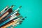 Set of paint brushes on the turquois background