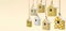 A set of painted birdhouses are suspended on a rope. Birdhouses with yellow and white patterns isolated on a light yellow backgrou