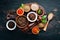 A set of peppers. Black pepper, colored pepper, ground pepper, dried chili pepper. Top view. On a black background.