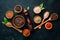 A set of peppers. Black pepper, colored pepper, ground pepper, dried chili pepper. Top view. On a black background.