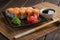 Set of Philadelphia Sushi Roll set on ceramic plate with wasabi, ginger, soy sauce and chopsticks